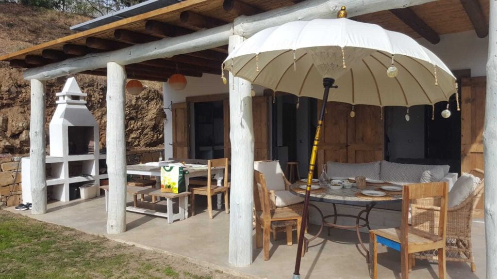 Covered veranda with outdoor dining table and parasol – Finca Vista Lago Istán