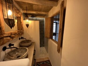 Bathroom with rustic sinks and mirror at Casa Aduar 22 Marbella