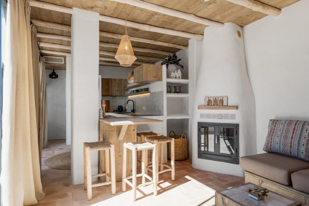 Open-plan rustic kitchen with bar stools at Casa Aduar 22 Marbella