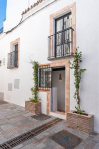 Front entrance with plants and whitewashed facade at Casa Aduar 22 Marbella Old Town
