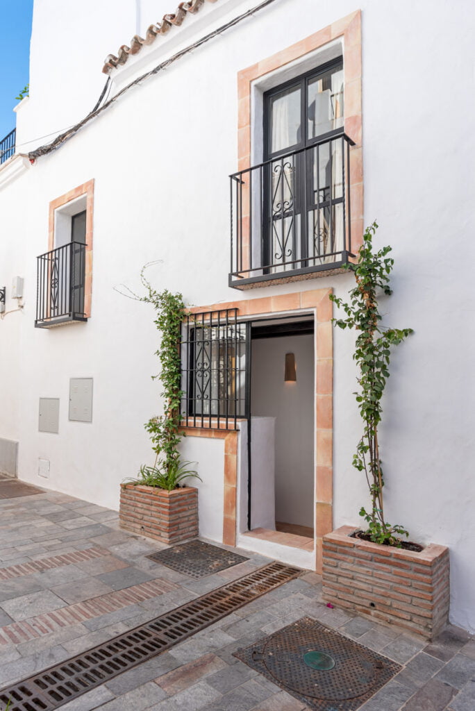 Front entrance with plants and whitewashed facade at Casa Aduar 22 Marbella Old Town