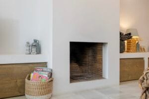 Cozy fireplace corner with decorative basket – Jardín de los Pinos Marbella