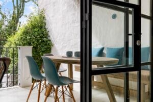 Dining area viewed through glass door with outdoor terrace – Jardín de los Pinos Marbella