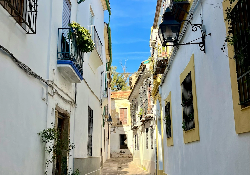 Narrow street in the Judería district of Córdoba with whitewashed houses and balconies