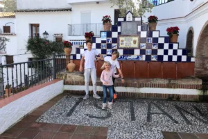 Family sitting on traditional tiled bench in Istán village near Marbella, Andalusia