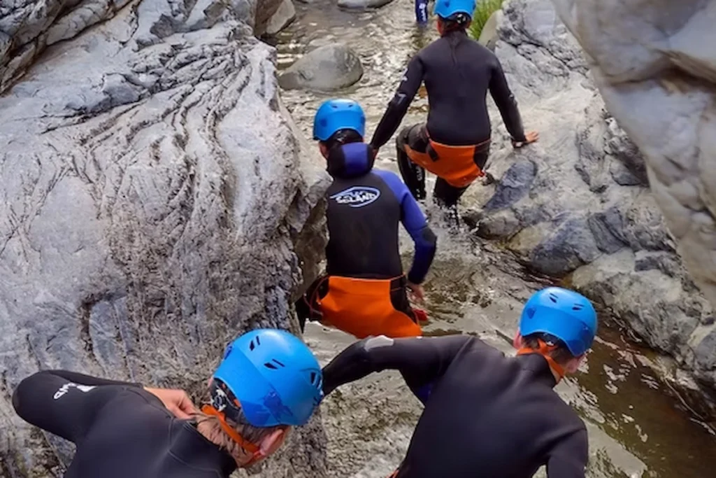 Group canyoning in Benahavís river gorge near Marbella wearing helmets and wetsuits