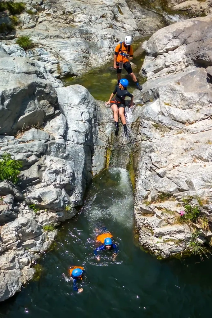 Canyoning in Benahavís with climber descending a waterfall into a natural rock pool