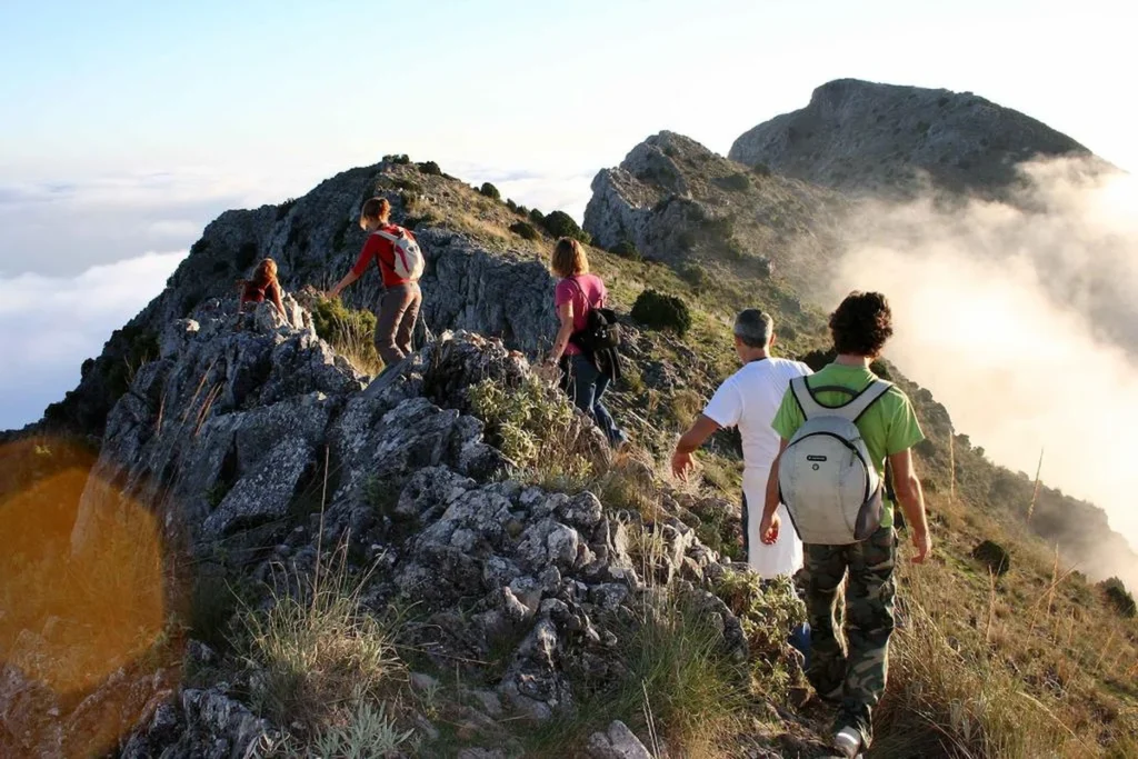 Hikers on a mountain ridge near Refugio de Juanar in Istán with views over the Sierra de las Nieves above Marbella