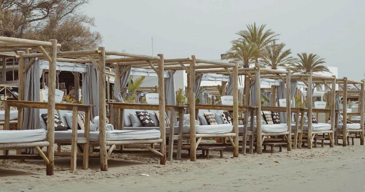 Casanis Plage Marbella beach club cabanas with wooden sunbeds on the beach